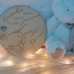 Porte-bracelet de naissance en bois posé sur une étagère, décoration naturelle pour chambre de bébé au style bohème et doux.