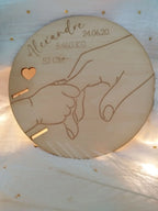 Porte-bracelet de naissance rond en bois gravé avec les informations de bébé – prénom, date, heure, poids et taille – décoration naturelle et artisanale.