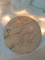 Porte-bracelet de naissance en bois accueillant le bracelet de maternité du bébé, idée cadeau naissance unique et personnalisée.