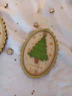 Décoration de Noël personnalisée “Vintage” en bois peint à la main, version sapin vert non pailleté avec ruban en mousseline beige, style chaleureux et champêtre.