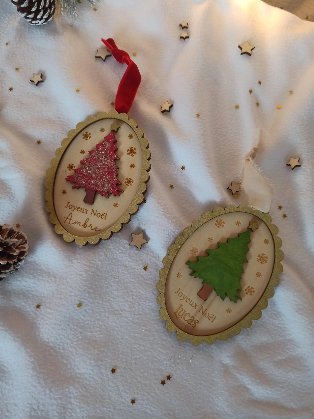Suspension de Noël vintage personnalisée avec prénom gravé, ornée de flocons dorés et d’un sapin scintillant, ambiance féerique sous guirlandes lumineuses.