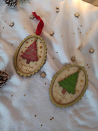 Suspension de Noël vintage personnalisée avec prénom gravé, ornée de flocons dorés et d’un sapin scintillant, ambiance féerique sous guirlandes lumineuses.