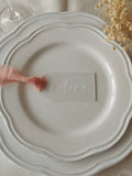 Marque-place en plexiglas personnalisé avec ruban en mousseline rose sur assiette de mariage