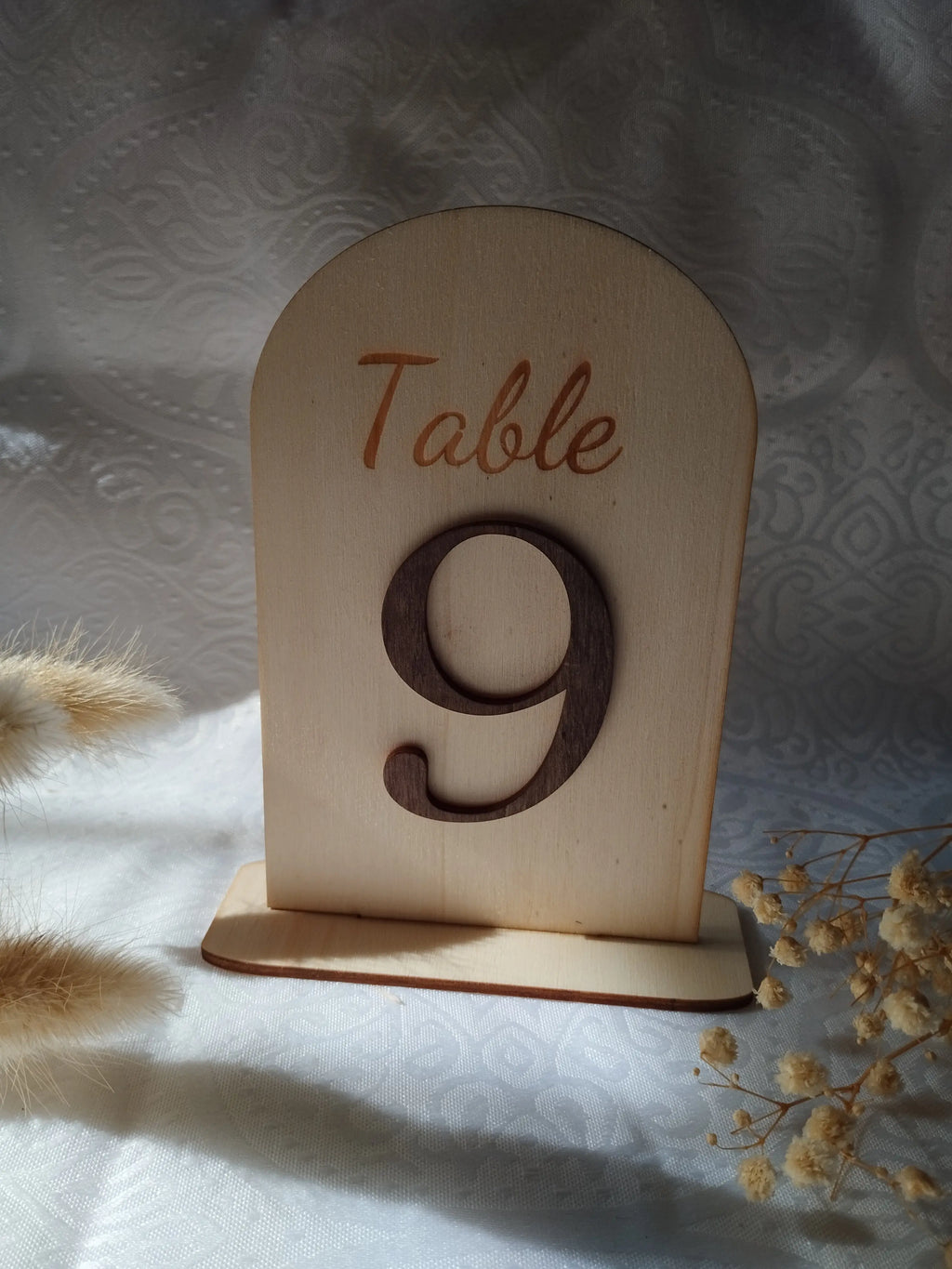 Détail de la gravure sur numéro de table en bois pour décoration de mariage