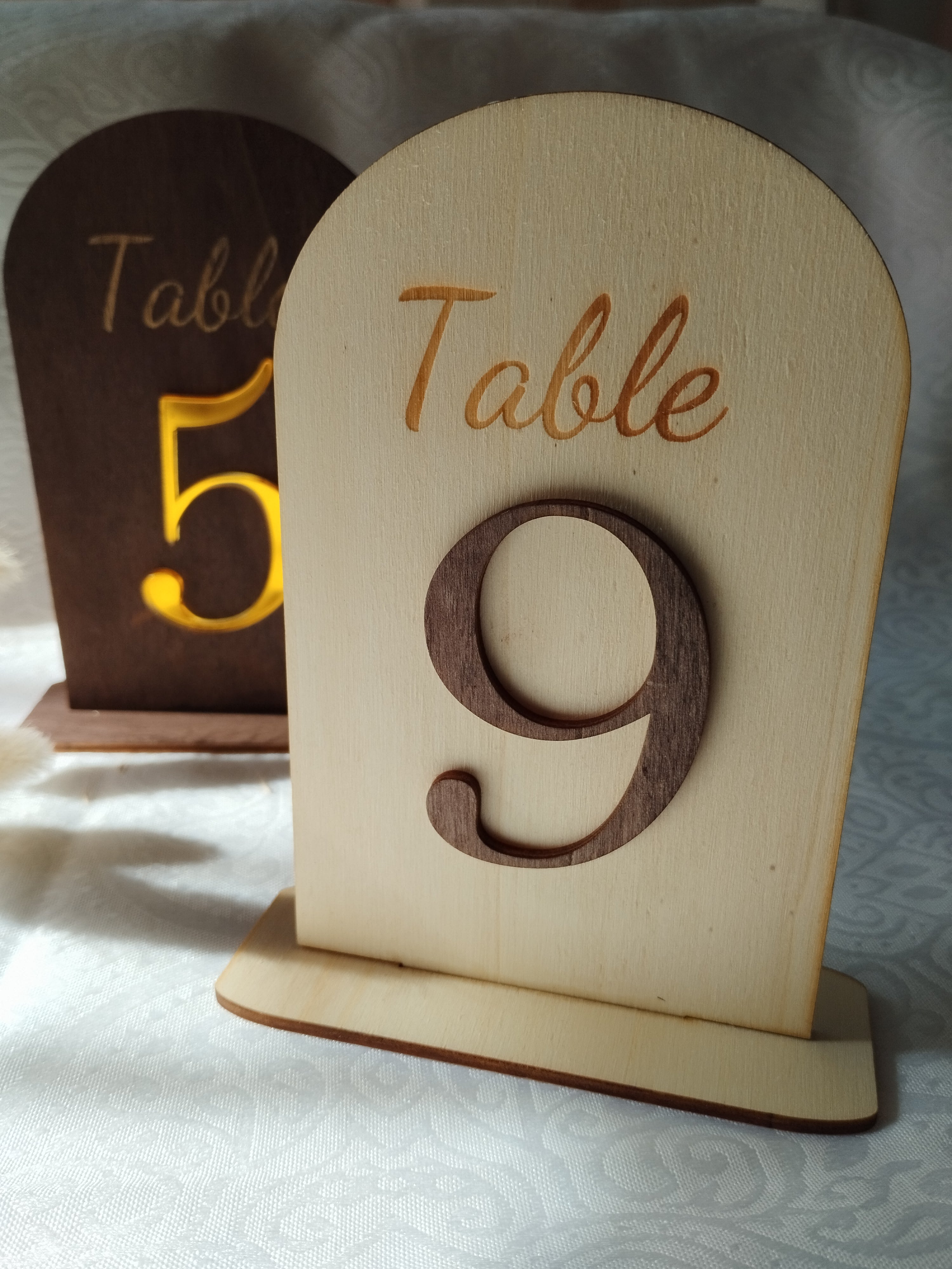 Numéro de table en bois posé sur une table de mariage à la décoration champêtre