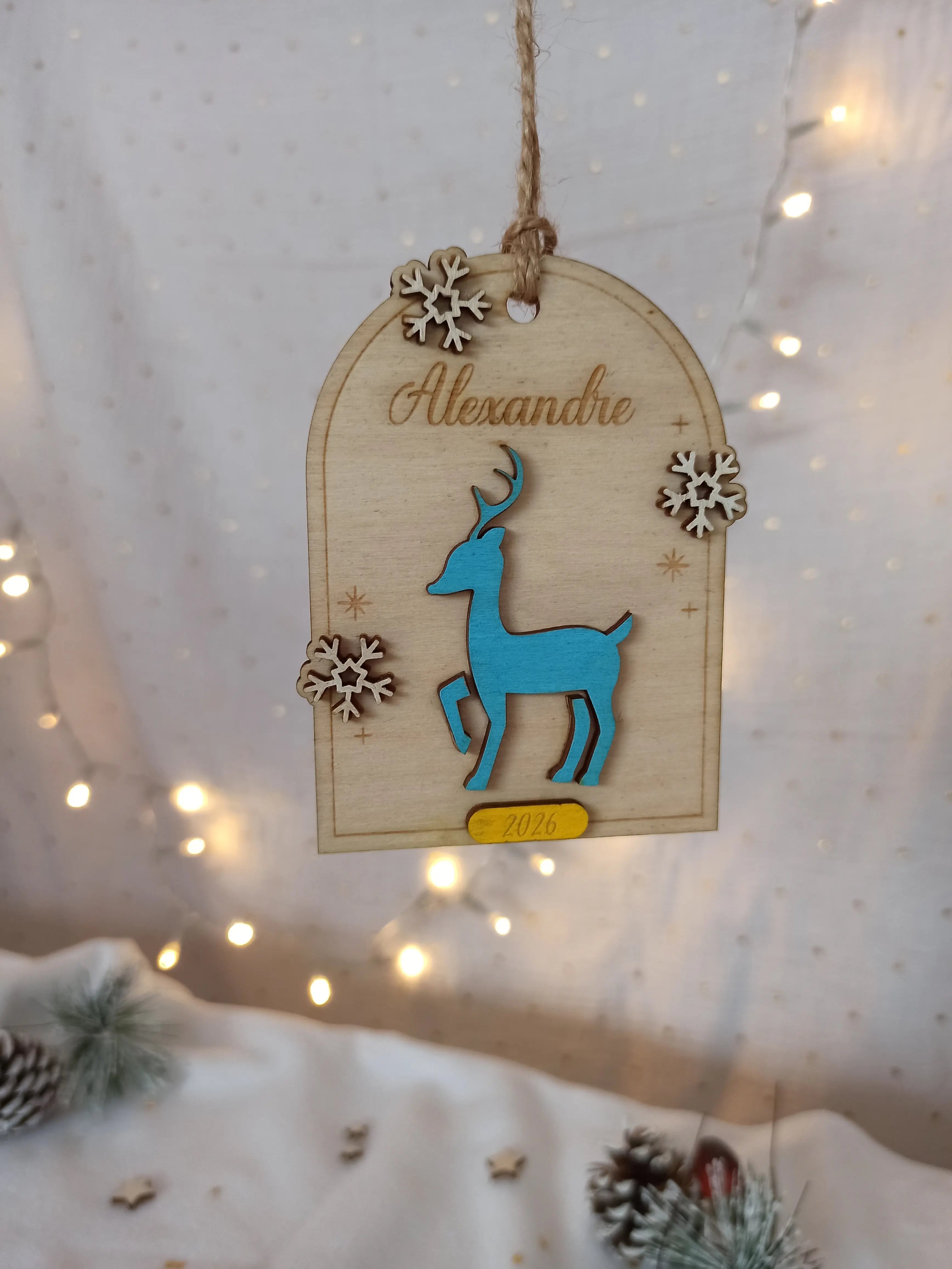Suspension de Noël personnalisée “Petit Renne” en bois de peuplier avec prénom gravé et flocons décoratifs, création artisanale féerique.
